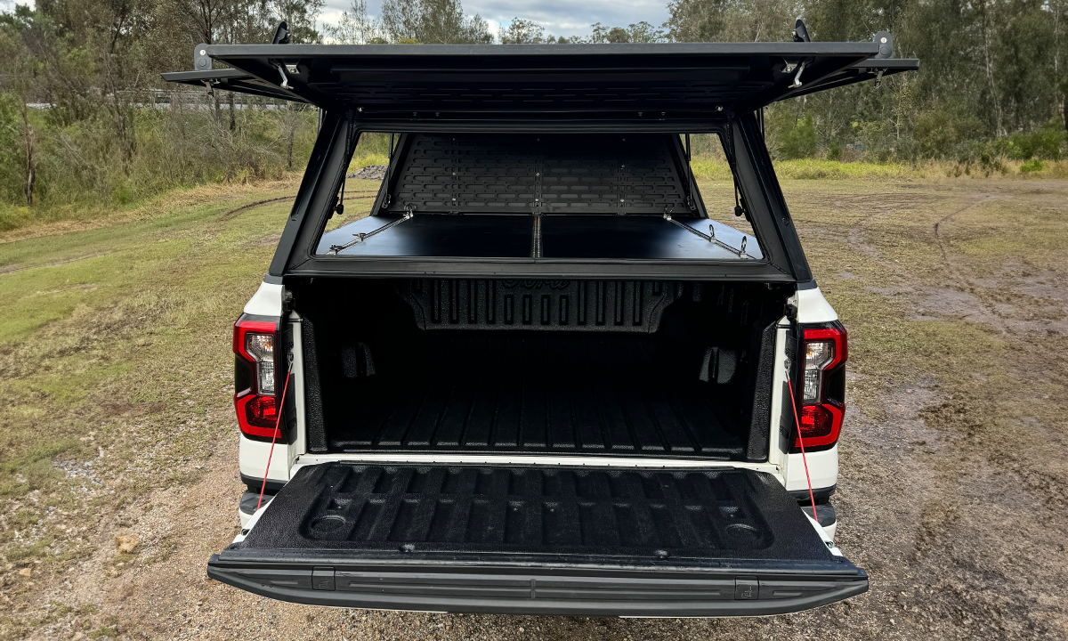 Rear view of a white Ford Ranger fitted with a DMW tub replacement canopy, showing the tailgate and canopy doors open to reveal a spacious, lined tub with integrated internal floor. This setup offers secure, weatherproof gear storage ideal for trade, touring, or recreational use.