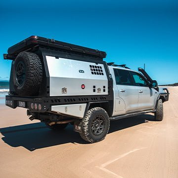 Three-quarter rear view of XTR Canopy on a 200 Series converted dual cab LandCruiser, showcasing rugged styling and touring-ready storage in an off-road setting