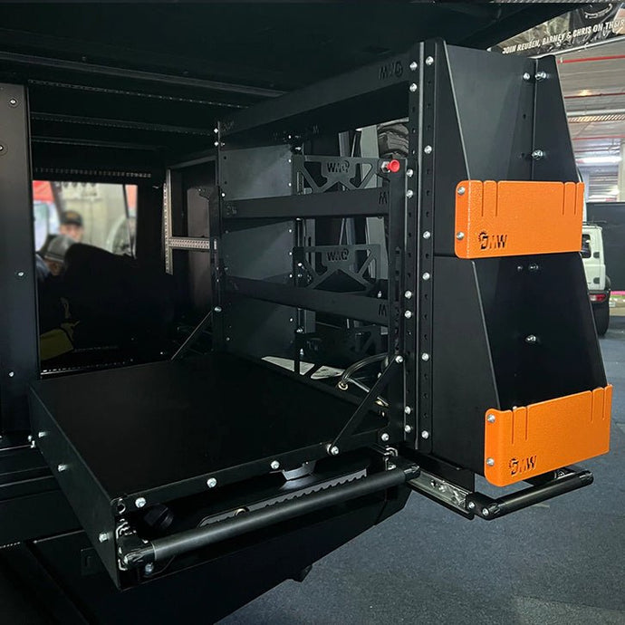 A DMW Compact Slide-Out Kitchen and Pantry system featuring a robust slide-out tray, precision-cut frame supports, and orange powder-coated end caps. Transform your camping cooking with the cutting-edge DMW Compact Kitchen/Pantry.